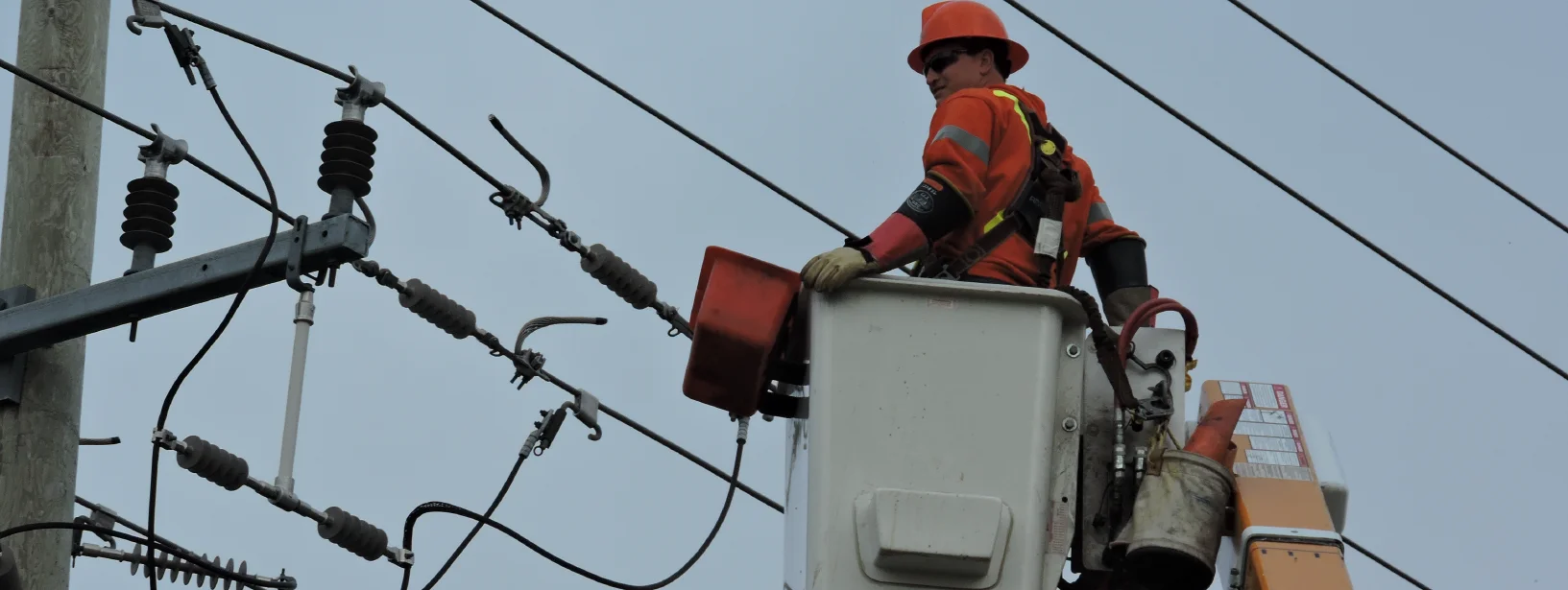 Utility construction worker in bucket with hard hat on